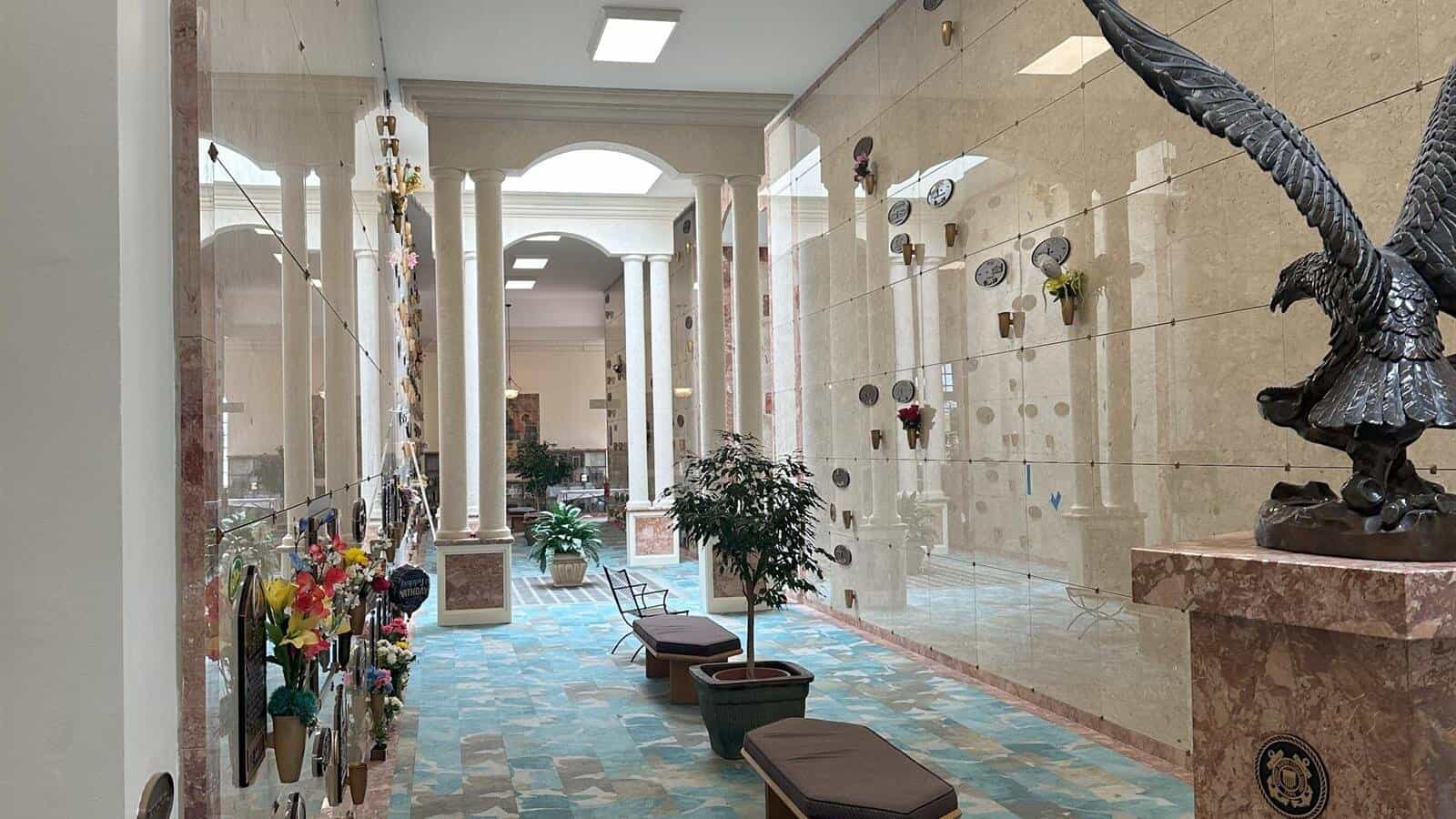 View of mausoleum corridor with memorial plaques and decorative sculptures.