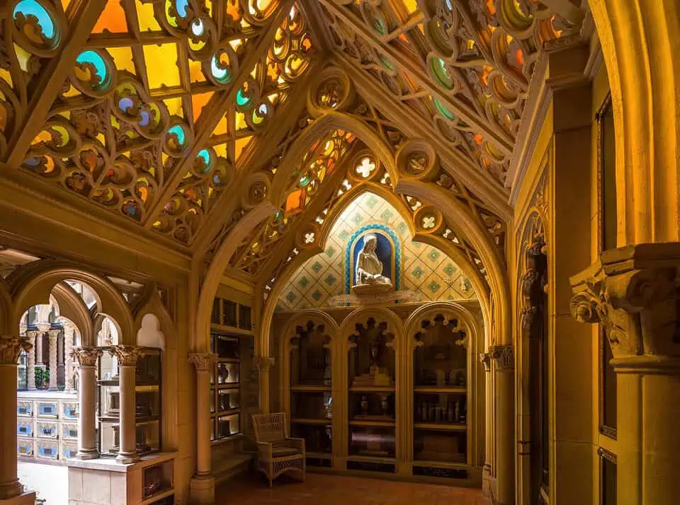 Intricate stained glass ceiling and decorative woodwork inside a chapel.