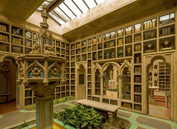 Interior view of a mausoleum with ornate woodwork and a central fountain.