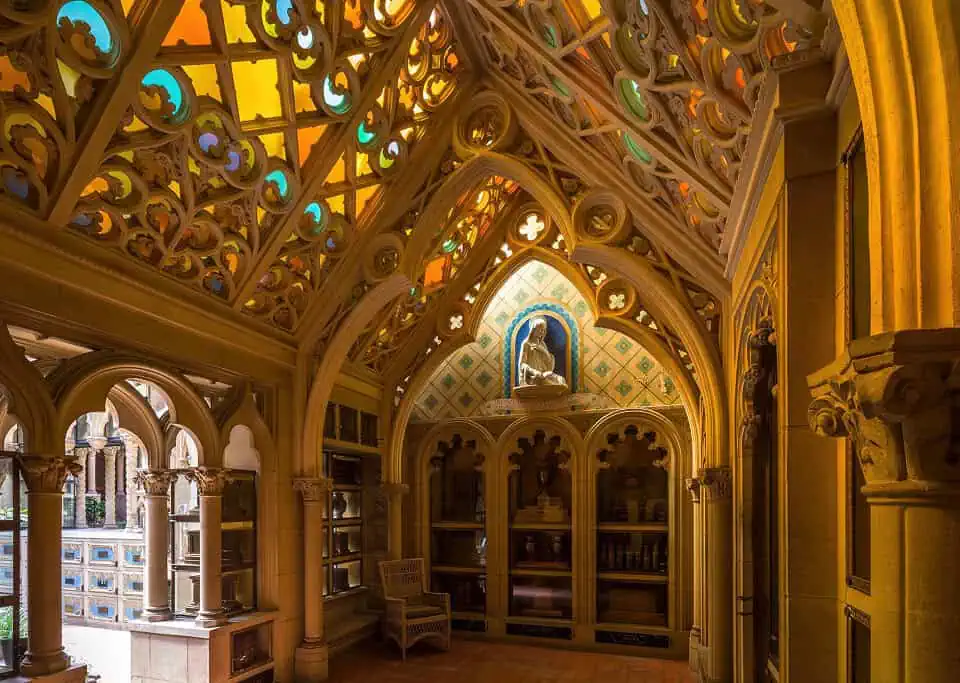 Intricate Gothic-style chapel interior with stained glass windows and ornate woodwork.