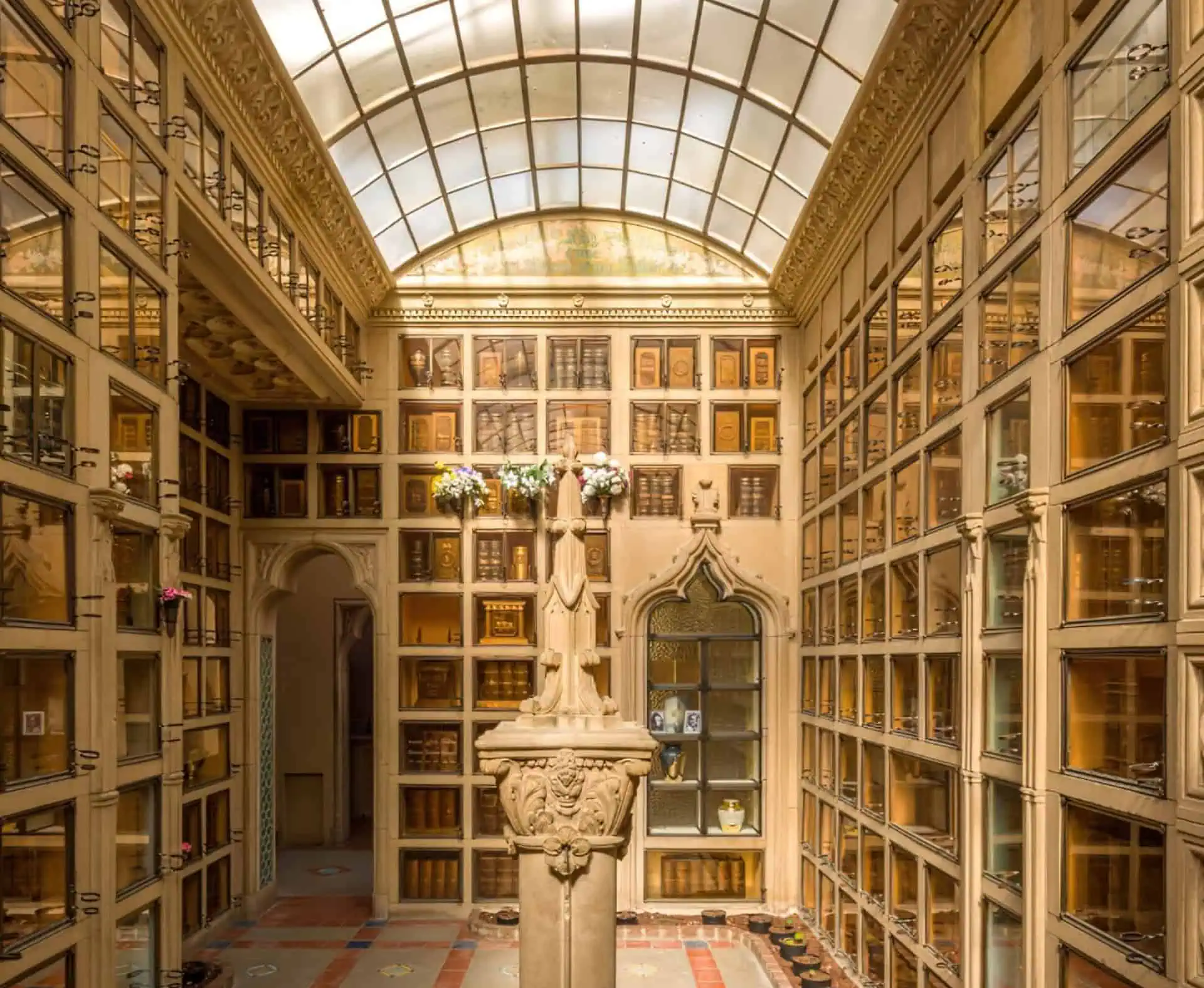 Elegant mausoleum with a glass ceiling and wall of niches for urns or caskets.