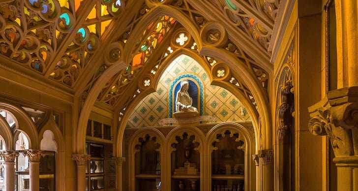 Intricate Gothic-style chapel with stained glass windows and a central statue.