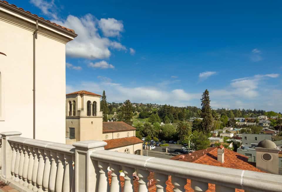 View from a balcony overlooking Oakland with trees and buildings.