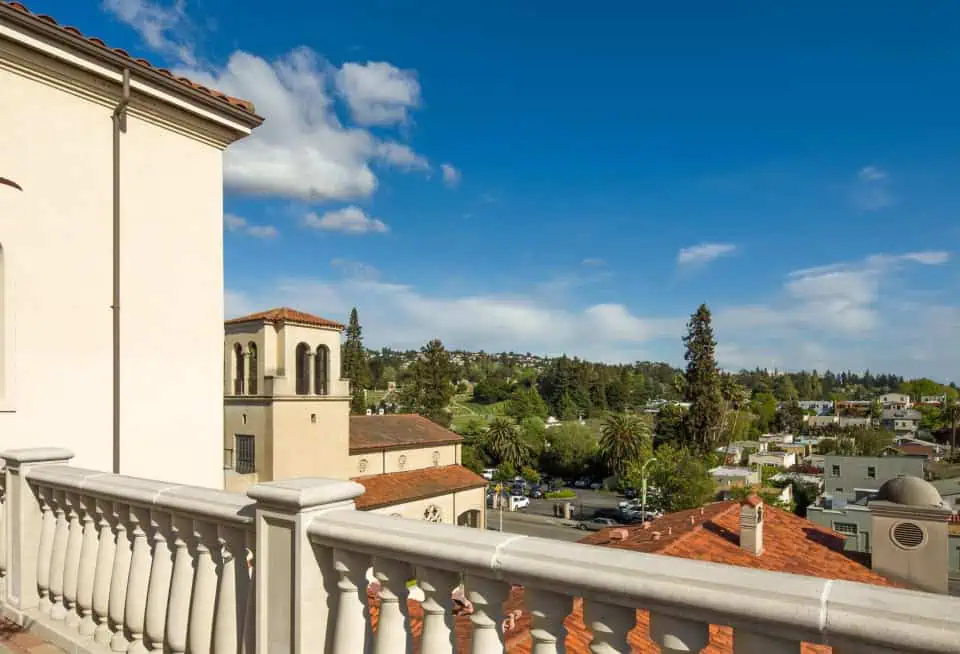View from a balcony overlooking Oakland with trees and buildings.