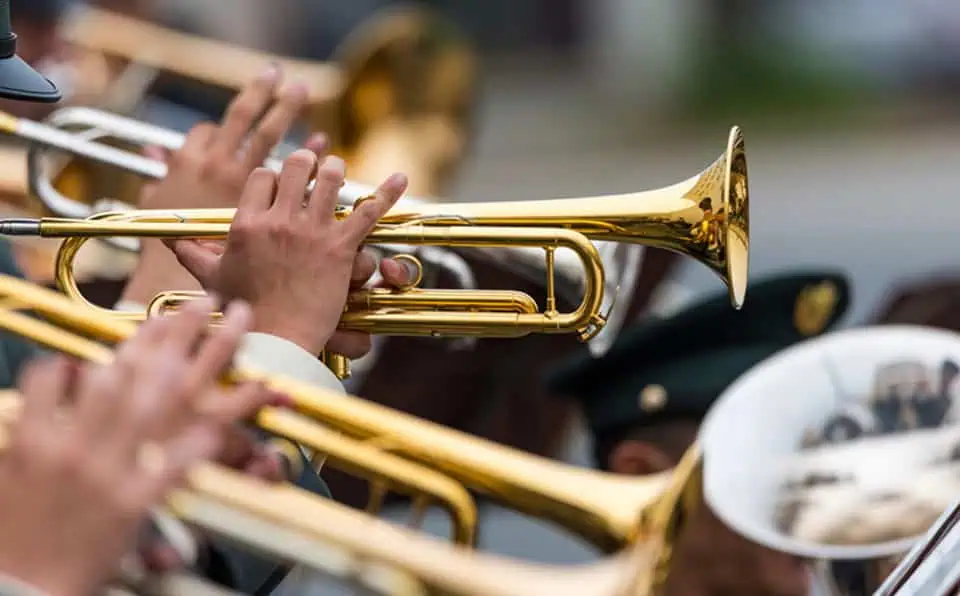 Military honor guard playing trumpets during a ceremony.