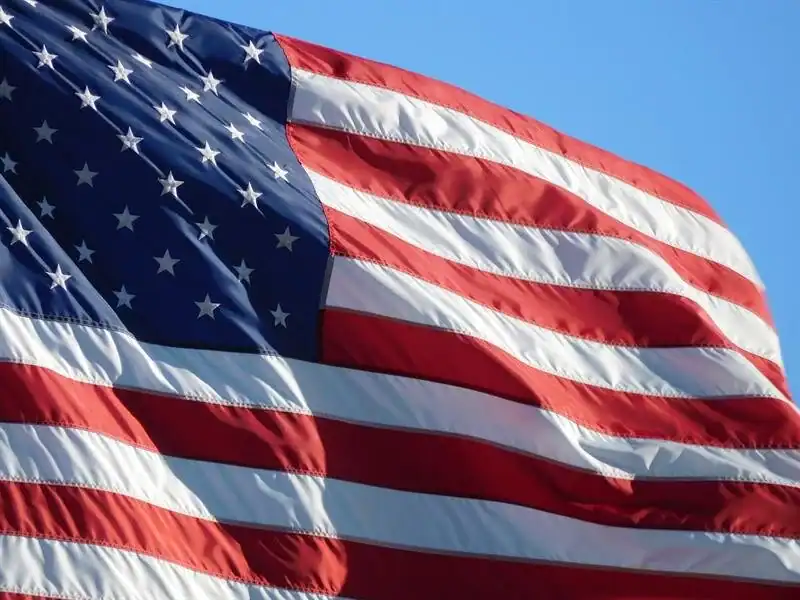American flag waving in the wind against a clear blue sky.