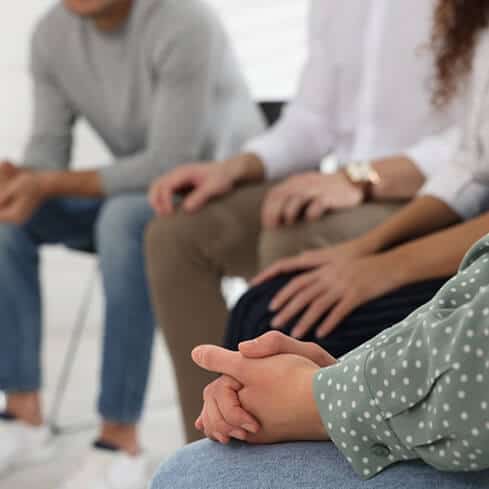People sitting in a circle during a grief support group session.